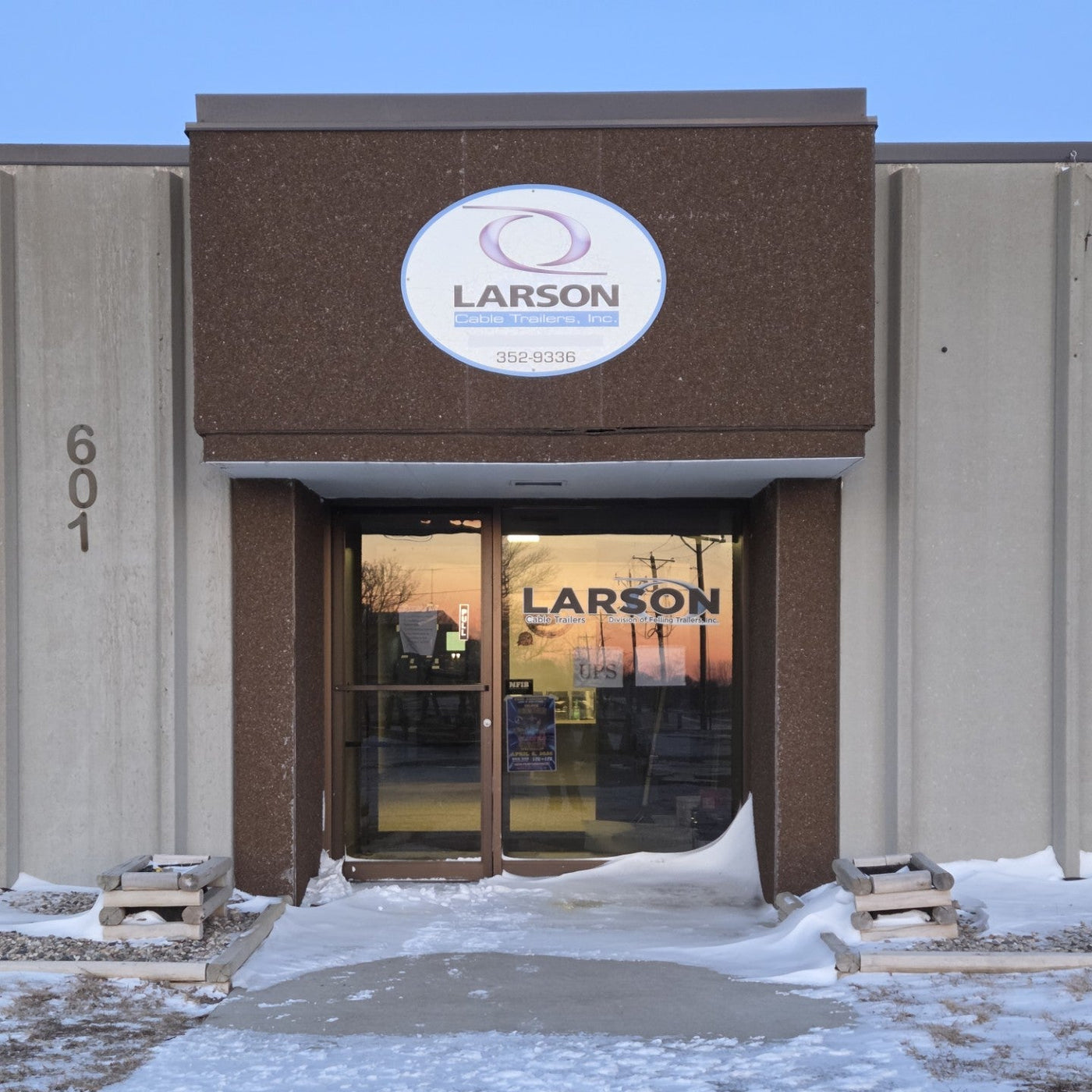 Building entrance with Larson logo at sunset, snow on ground