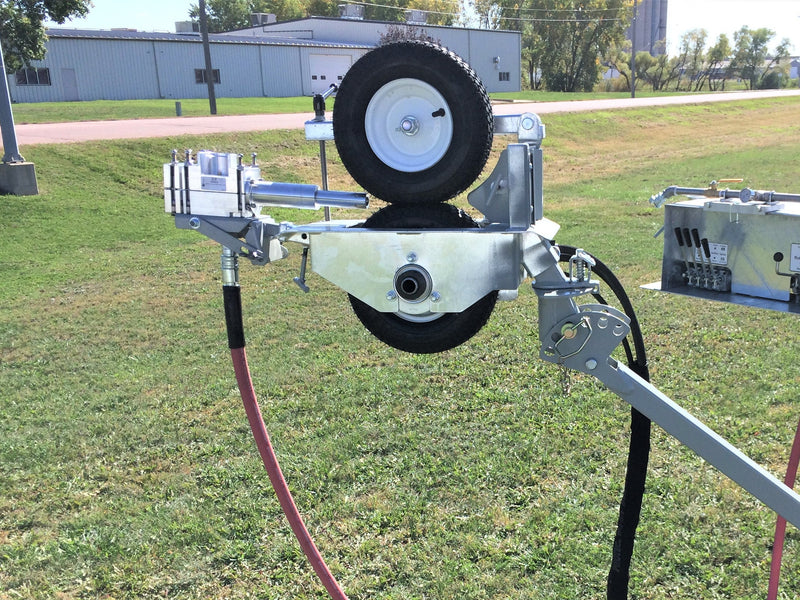 Mechanical device with wheels and hoses on a grassy area