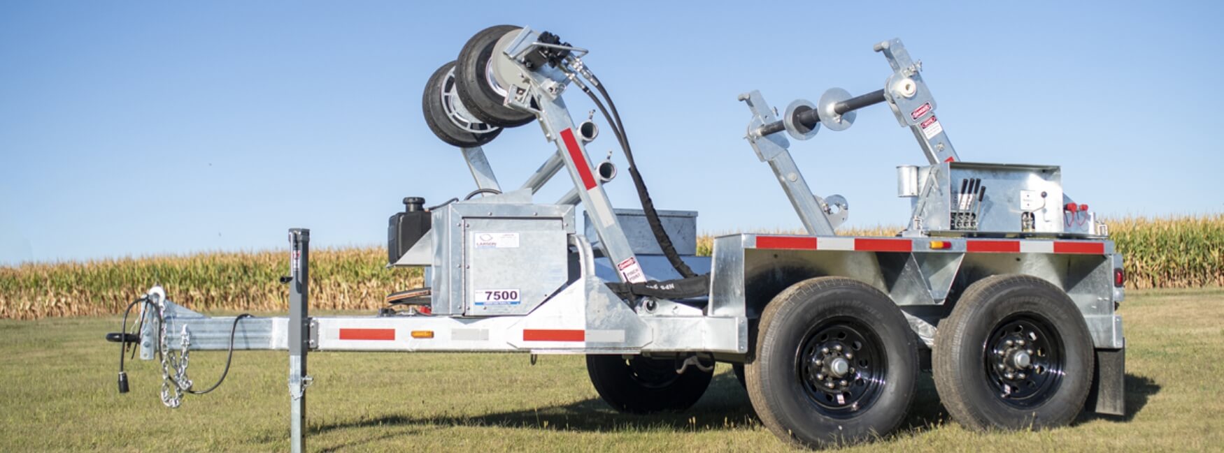 Tow truck with winch and towing equipment on a grassy field.